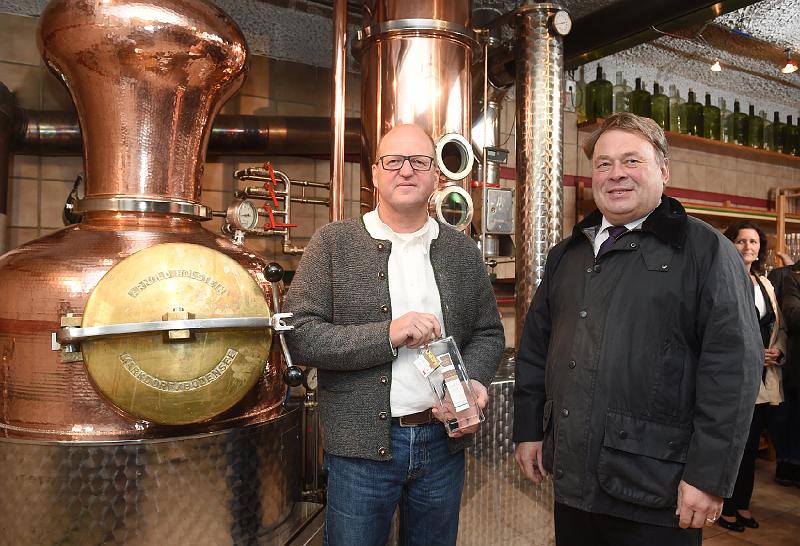 2016_10_14stmelf0178_be.jpg - Betriebsleiter Thomas Koller und Staatsminister Helmut Brunner mit Edelbrand vor der Destille bei der Betriebsbesichtigung des Betriebs Koller in Greilsberg. Foto: Tobias Hase/StMELF